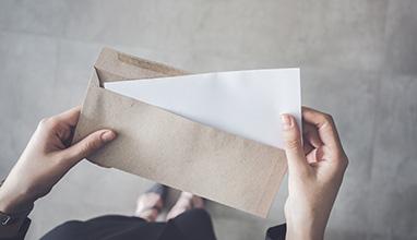 Stand up woman holding white folded a4 paper and brown envelope