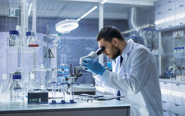 Research Scientist Looks into Microscope. He's Conducts Experiments in Modern Laboratory.