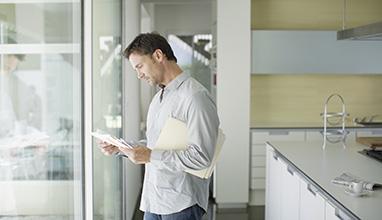 Male reading a letter in his house in front of a window