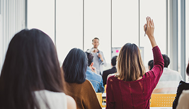 Back view business woman raising hand for asking speaker for question and answer concept in meeting room for seminar