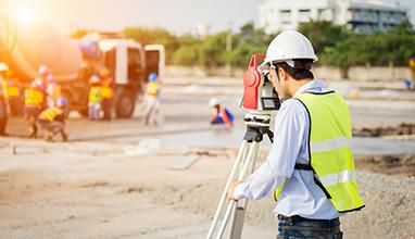 Engineer surveyor working with theodolite at construction site