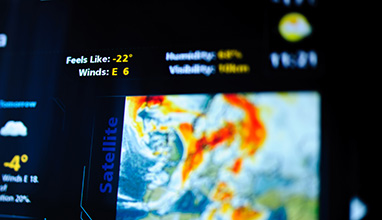 Digital weather forecast interface on a modern digital display showing cold weather for the next day eaturing an unrecognizable weather map. Tilt-shift lens used to outline the feels like -22 symbol