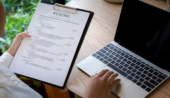 Business man review his resume application on desk, laptop computer, job seeker