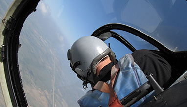 Male aerobatic pilot flying a plane