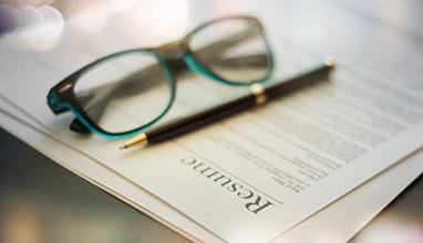 Printed resume with glasses and a pen on top of the resume