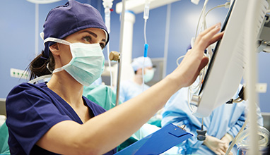 Nurse working with vital signs monitor at an operating room