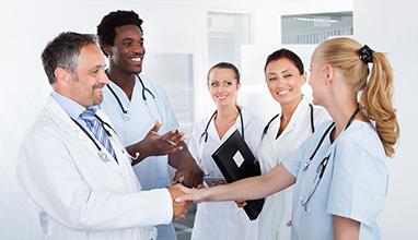 Woman doctor shaking hands with a group of doctors