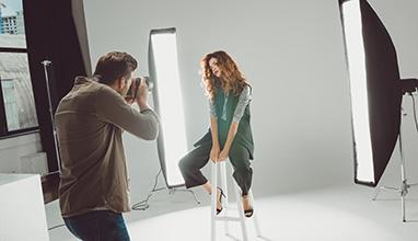 Photographer taking pictures of a model in a studio