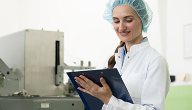 Woman writing on a paper dressed in lab attire