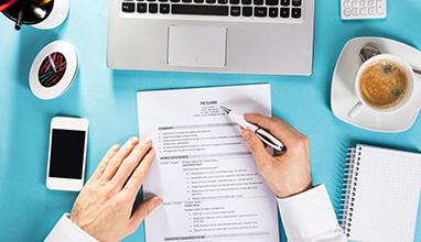 Businessman reading a resume at a desk 