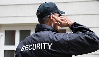 Male security guard listing to his radio