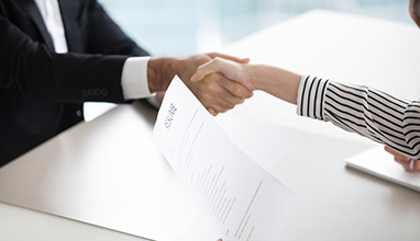 Woman and man shaking hands at an job interview