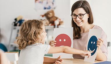 Woman special education teacher teaching young school girl