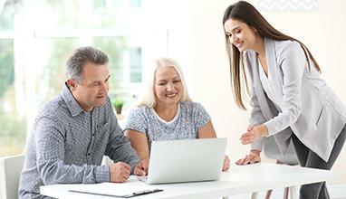 Woman underwriter speaking to elderly couple.