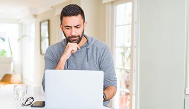 Frustrated male looking at his laptop