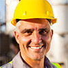 Portrait of a man wearing a hard hat and safety jacket in a factory