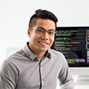 Portrait of a male technician coding in two computer monitors at his desk