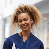 Woman wearing medical scrubs holding a clip board
