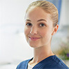 Woman wearing medical scrubs holding files