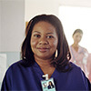 Woman wearing medical scrubs and her team of nurses standing behind her