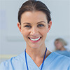Woman wearing medical scrubs. A doctor is in the background attending a patient