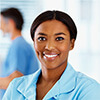 Woman wearing medical scrubs. Doctors and nurses in the background