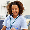 Woman wearing medical scrubs revising medical forms at her desk