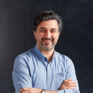 Portrait of a male teacher in front of a blackboard