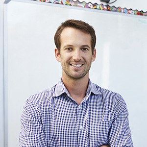 Portrait of a male teacher in front of a whiteboard